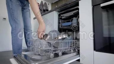 女人在洗碗机里装<strong>脏盘子</strong>